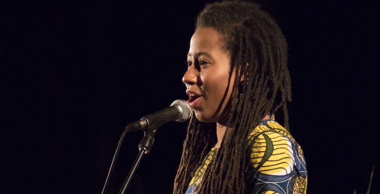 Black woman reading into a microphone
