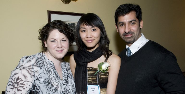 Two young women and a man smiling into the camera