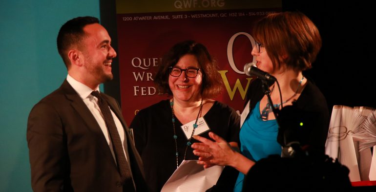 Young man and two women talking at a microphone