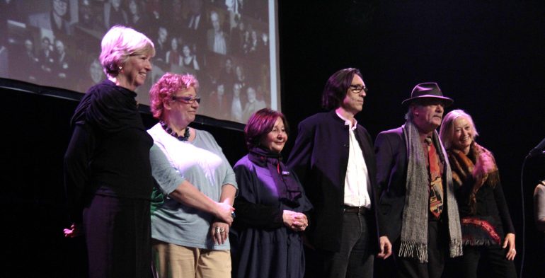 Four women and two men on stage