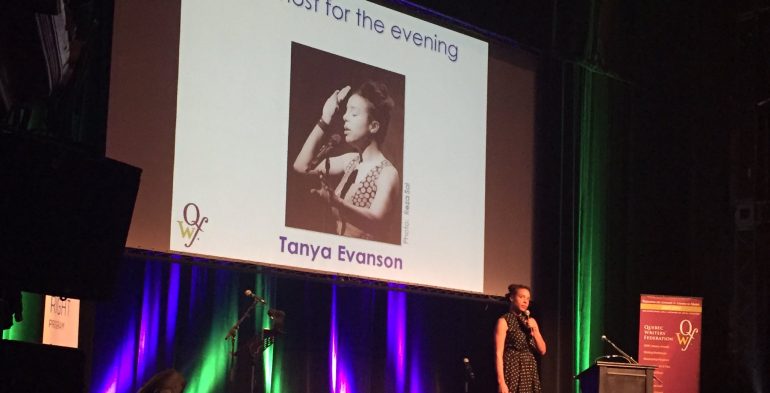 Young woman of colour speaking into a microphone