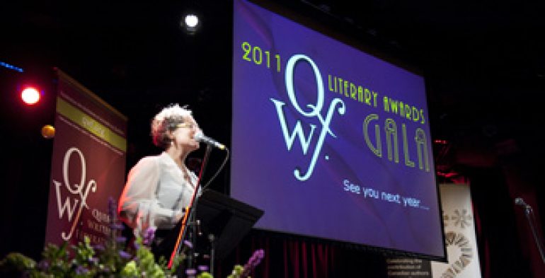 Woman wearing glasses reading into microphone