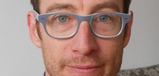 A white man wearing glasses