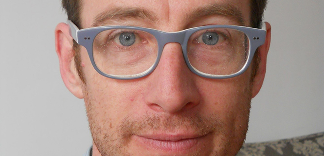 A white man wearing glasses