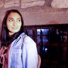 young woman looks over her shoulder into the light